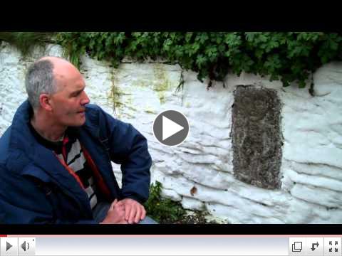 Micheal Fox examines a Sheela Na Gig Stone Carving near Ardath, County Meath, Ireland